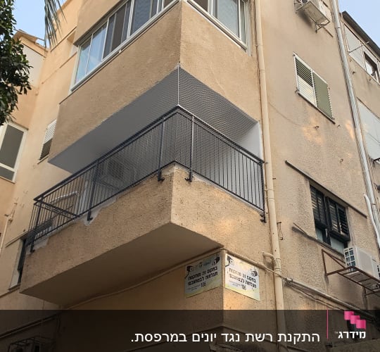 רשת יונים מותקנת על מרפסת בניין מגורים